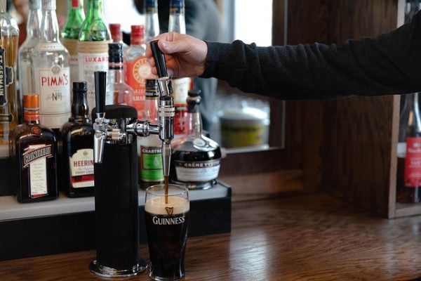 Top off your pint by pushing the tap handle from you. This limits the power of the flow. The beer should be set straight under the spout during this second pour.
